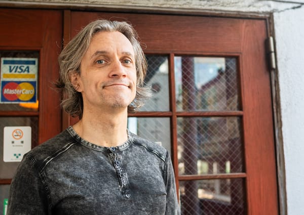 Derek Thomas, CEO/President of Pizzakaya standing in front of the entrance of his restaurant.